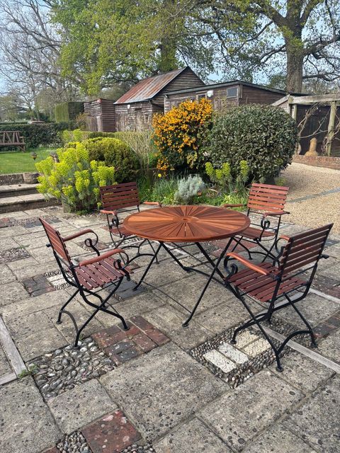 Sapele garden table and chairs set out in a country garden