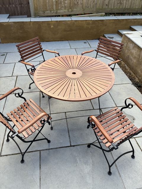 Sunburst segmented Sapele table top on its original black iron folding base