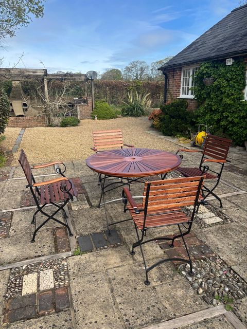 Sapele garden table and chairs on a brick and flint patio